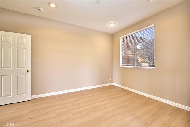 empty room featuring light wood-style flooring and baseboards