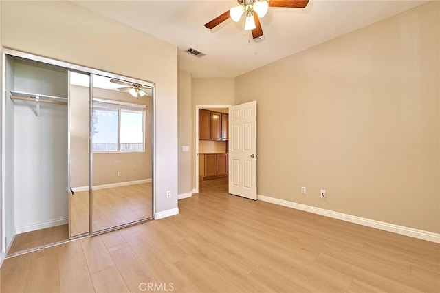 unfurnished bedroom with a ceiling fan, baseboards, visible vents, light wood finished floors, and a closet