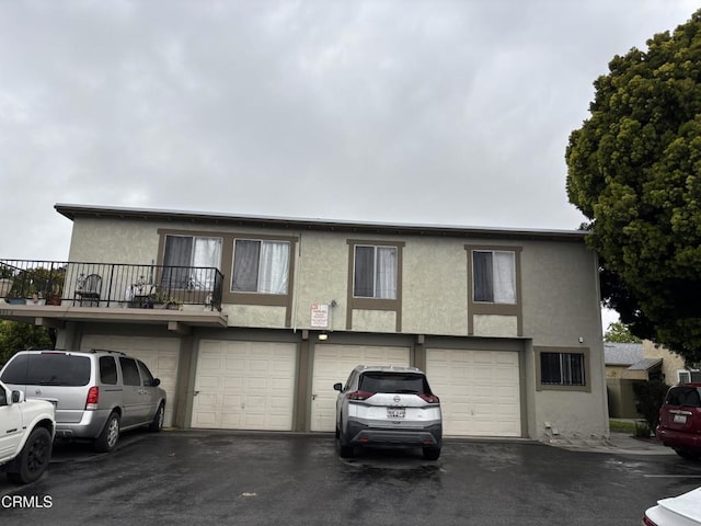 view of front of property with stucco siding, driveway, and an attached garage