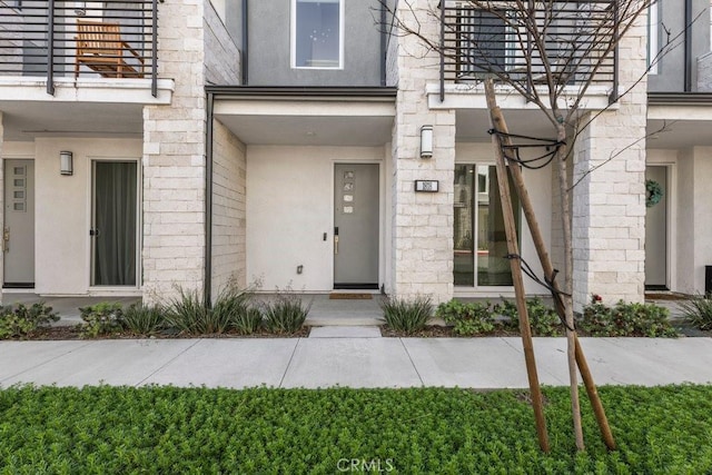 entrance to property featuring stucco siding