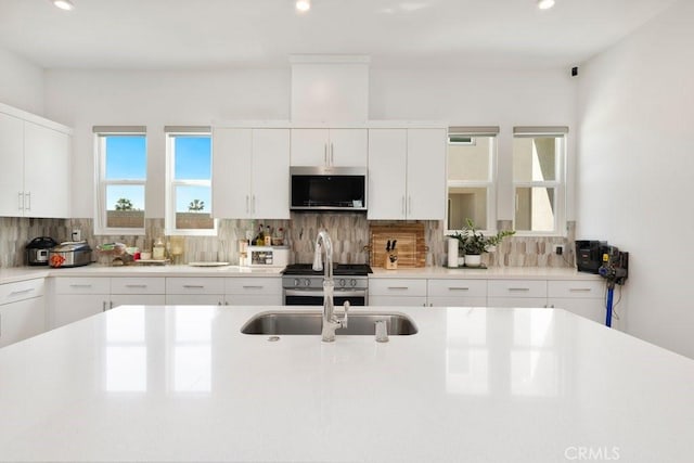 kitchen with decorative backsplash, plenty of natural light, appliances with stainless steel finishes, and light countertops