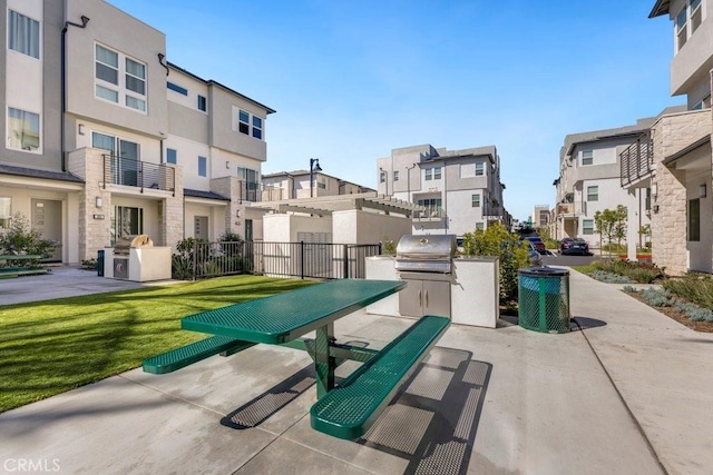 view of patio featuring a residential view, area for grilling, and an outdoor kitchen