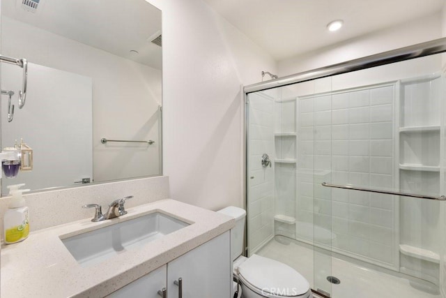 bathroom featuring visible vents, toilet, a stall shower, and vanity