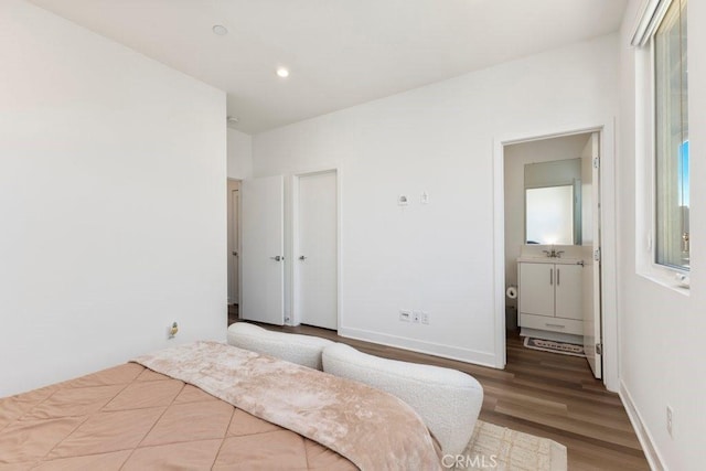 bedroom featuring a sink, baseboards, wood finished floors, and recessed lighting