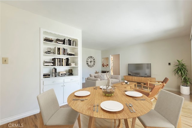 dining room featuring baseboards and light wood-style flooring