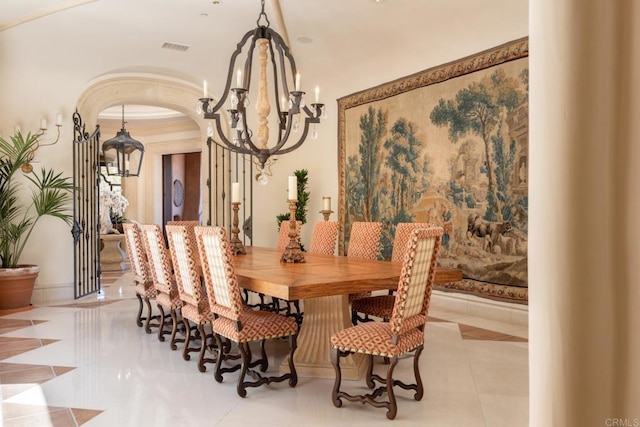 dining space featuring arched walkways, a chandelier, and visible vents