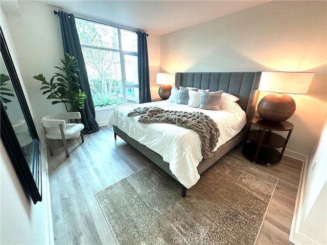 bedroom featuring wood finished floors and baseboards