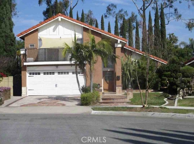 view of front facade with a garage, concrete driveway, and stucco siding