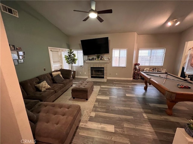 living room with a ceiling fan, wood finished floors, visible vents, baseboards, and vaulted ceiling