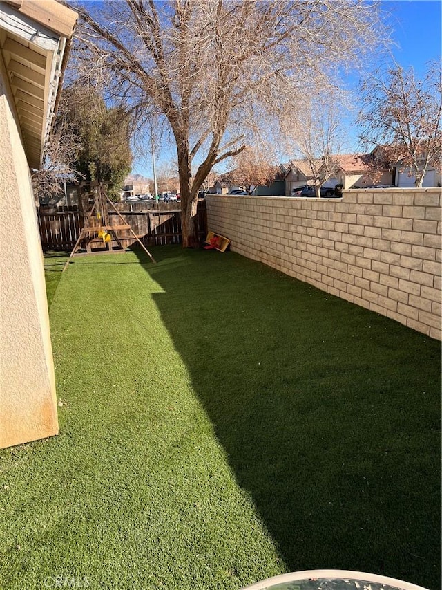 view of yard featuring a playground and a fenced backyard