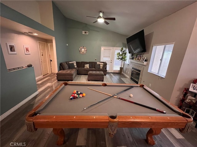 game room featuring a tiled fireplace, vaulted ceiling, wood finished floors, and visible vents