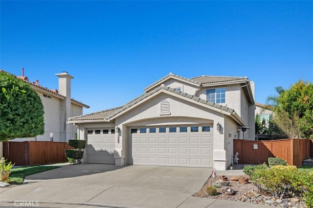 view of front of house featuring a tile roof, fence, a garage, and stucco siding