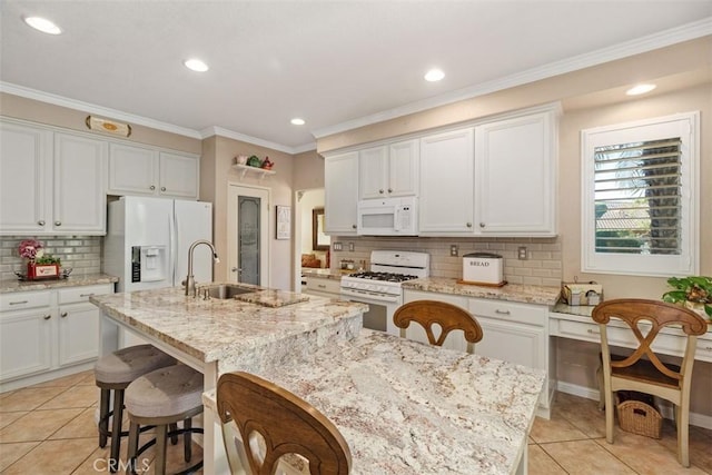 kitchen featuring a kitchen island with sink, a sink, white appliances, light tile patterned flooring, and crown molding