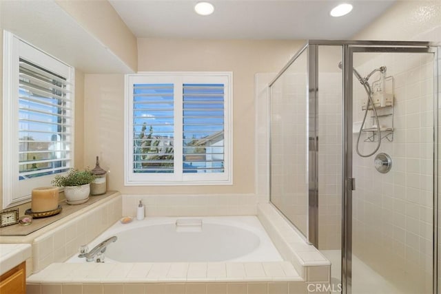 full bathroom with vanity, a bath, and a stall shower