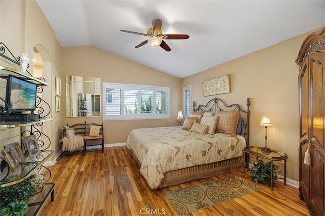 bedroom featuring baseboards, wood finished floors, a ceiling fan, and vaulted ceiling