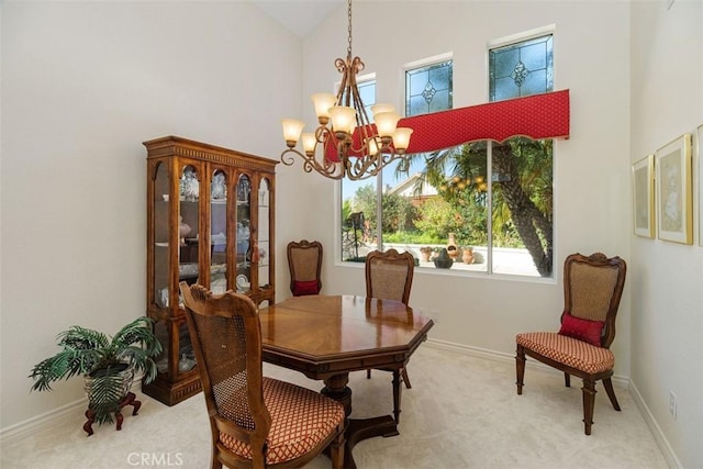 carpeted dining room with baseboards, high vaulted ceiling, and a chandelier