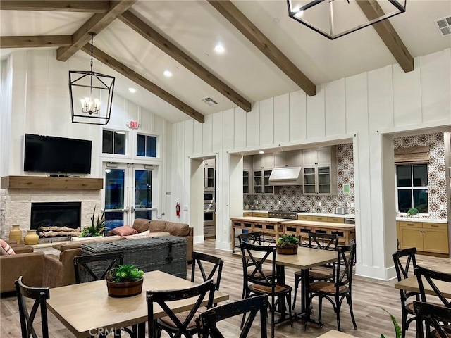 dining room with beam ceiling, light wood-type flooring, visible vents, and high vaulted ceiling