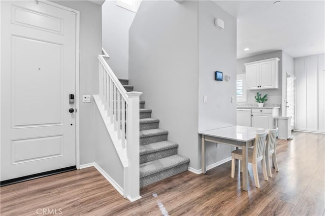 stairs featuring recessed lighting, baseboards, and wood finished floors