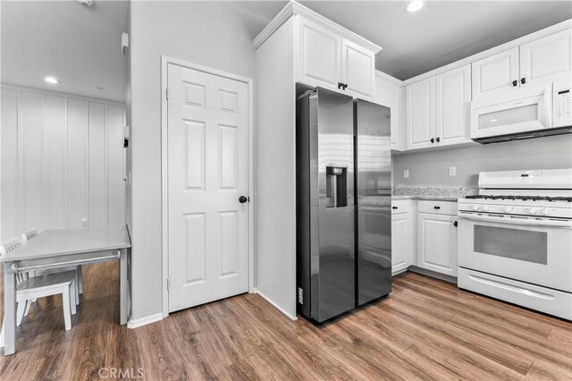 kitchen featuring light stone counters, recessed lighting, light wood-style floors, white appliances, and white cabinetry