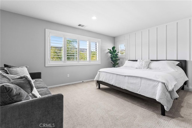 bedroom featuring visible vents, light colored carpet, and baseboards