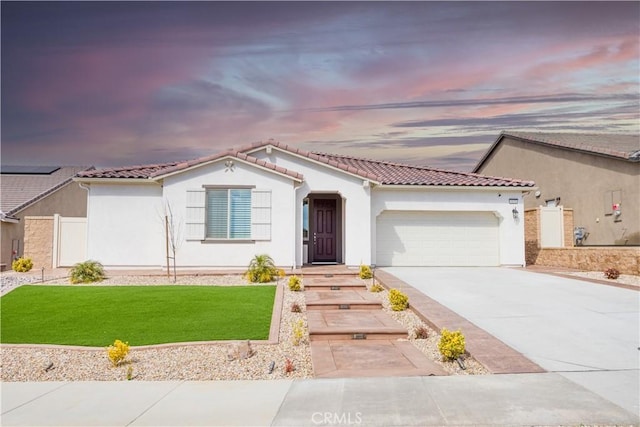 mediterranean / spanish-style house with stucco siding, driveway, an attached garage, and a tile roof