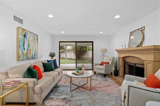 living room with visible vents, recessed lighting, a fireplace, and wood finished floors