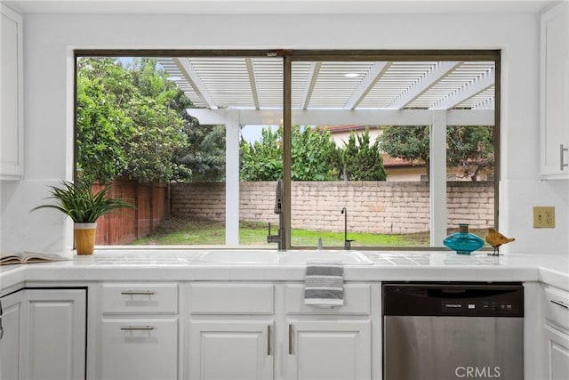 interior space featuring stainless steel dishwasher, decorative backsplash, and a sink