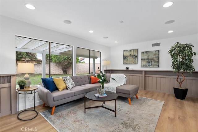 living room featuring recessed lighting, wainscoting, wood finished floors, and visible vents