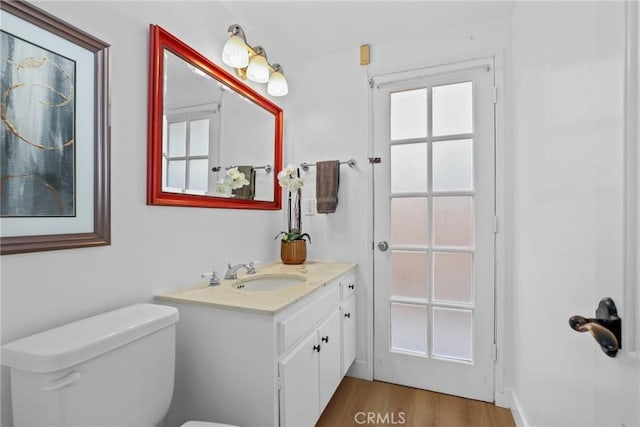 bathroom with vanity, toilet, and wood finished floors