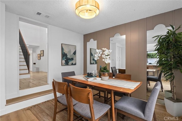11328 Felson St, Cerritos, CA 90703 - dining space featuring stairs, a textured ceiling, and wood finished floors