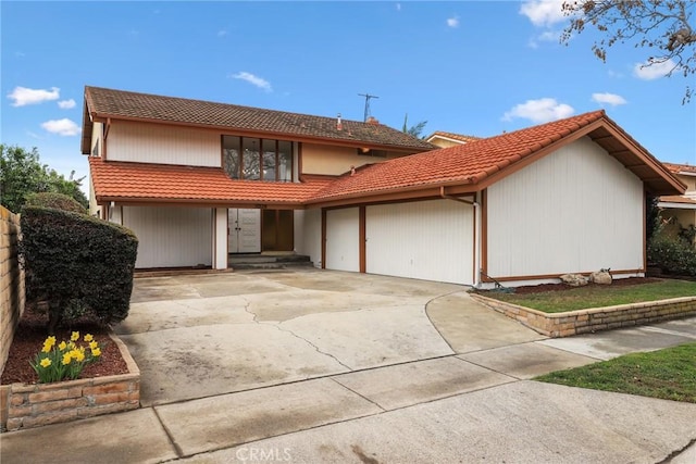 view of front of home with a tiled roof, concrete driveway, and a garage