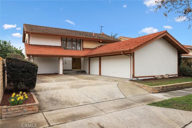 view of front of property with a tiled roof, concrete driveway, and a garage