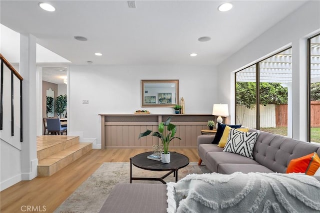 living room with recessed lighting, baseboards, wood finished floors, and stairs