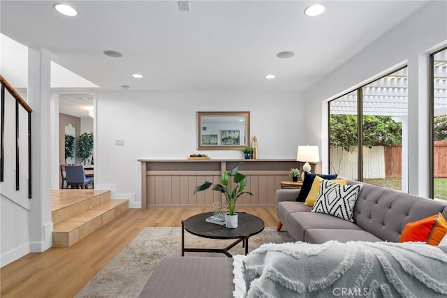 living area featuring stairs, recessed lighting, baseboards, and light wood-style flooring