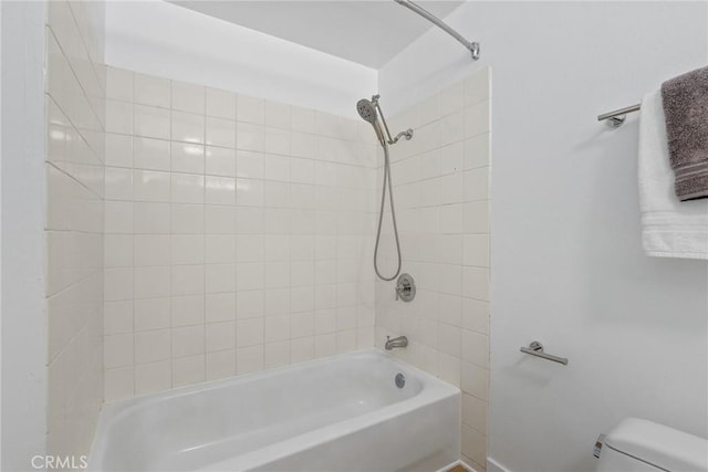 bathroom featuring tub / shower combination and toilet