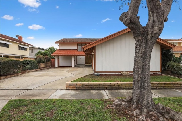 view of front of house featuring concrete driveway and a tiled roof