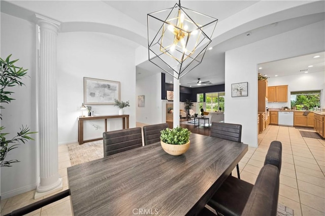 dining room featuring a wealth of natural light, light tile patterned flooring, and ornate columns