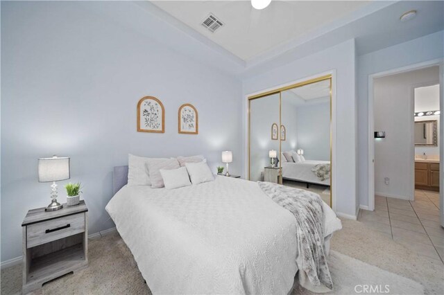 bedroom featuring visible vents, baseboards, light colored carpet, and a closet