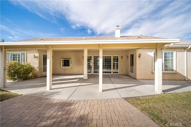 rear view of property with a patio area and stucco siding