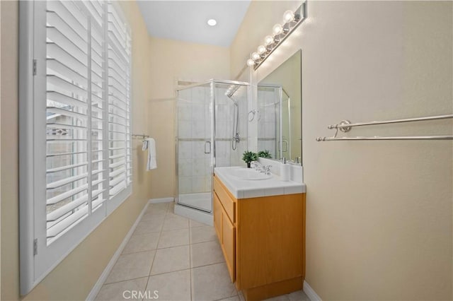 full bath with tile patterned flooring, a stall shower, vanity, and baseboards