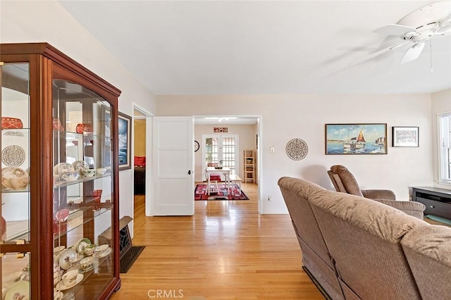 living area with light wood-style flooring and ceiling fan