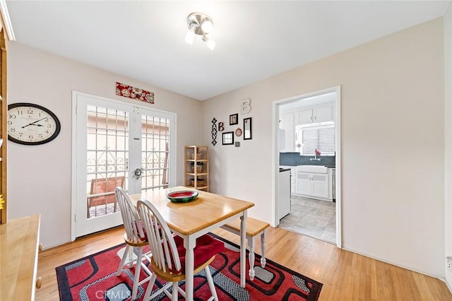 dining area featuring light wood-type flooring and french doors