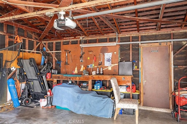 garage with a workshop area and a garage door opener