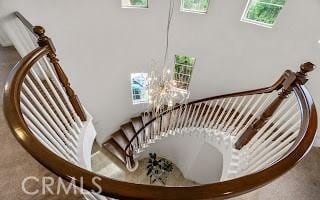 stairway featuring an inviting chandelier