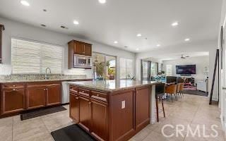 kitchen featuring a kitchen island, open floor plan, light tile patterned floors, recessed lighting, and stainless steel appliances