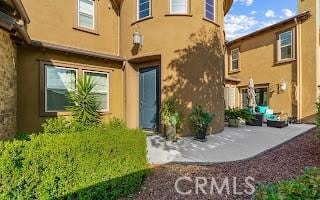 back of house featuring stucco siding and a patio area