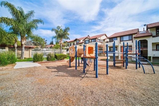 community jungle gym with a residential view and fence