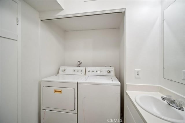 laundry area featuring laundry area, washing machine and dryer, and a sink