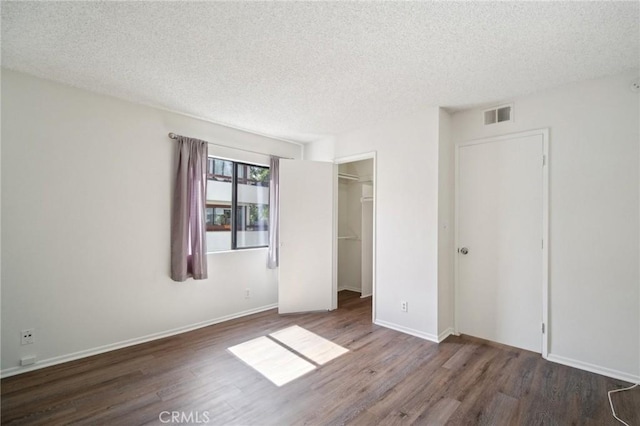 unfurnished bedroom with wood finished floors, visible vents, and a textured ceiling