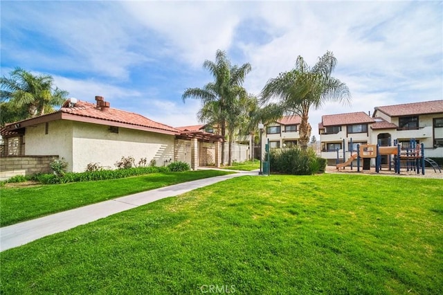 view of property's community featuring a lawn and playground community